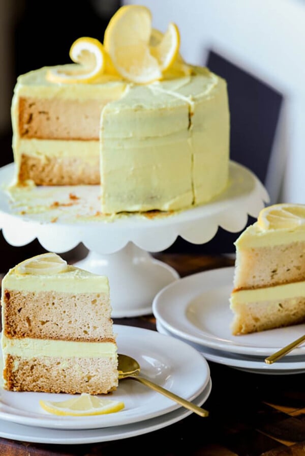 vegan lemon cake on the cake stand next to slices of the cake