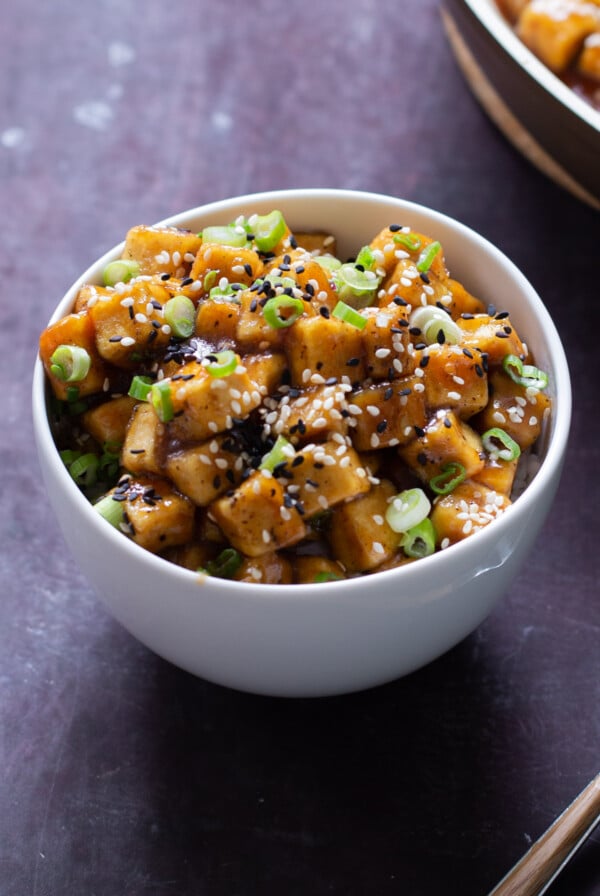 bowl of lemon pepper tofu topped with sesame seeds and green onions