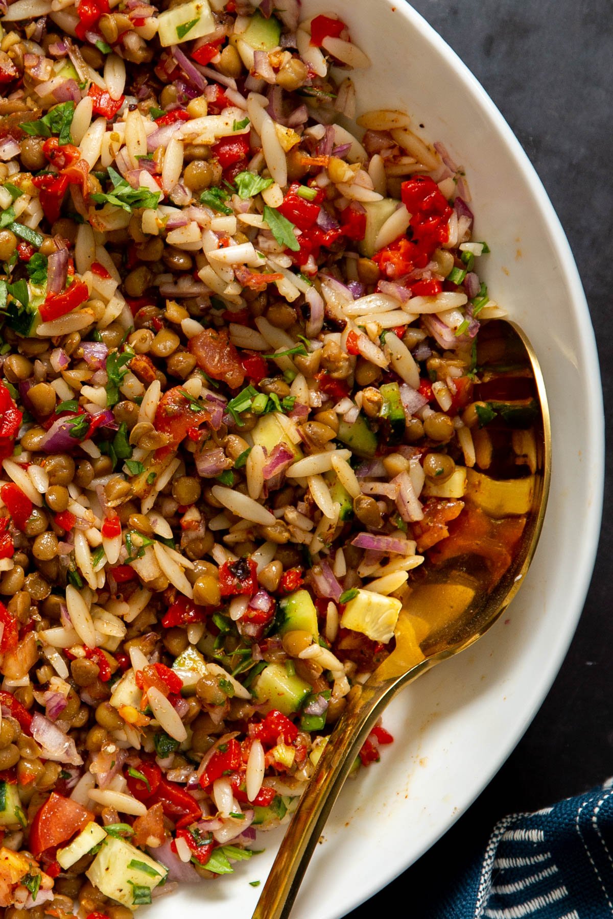 a bowl with vegan lentil farro salad with chopped veggies tossed in lemon vinaigrette