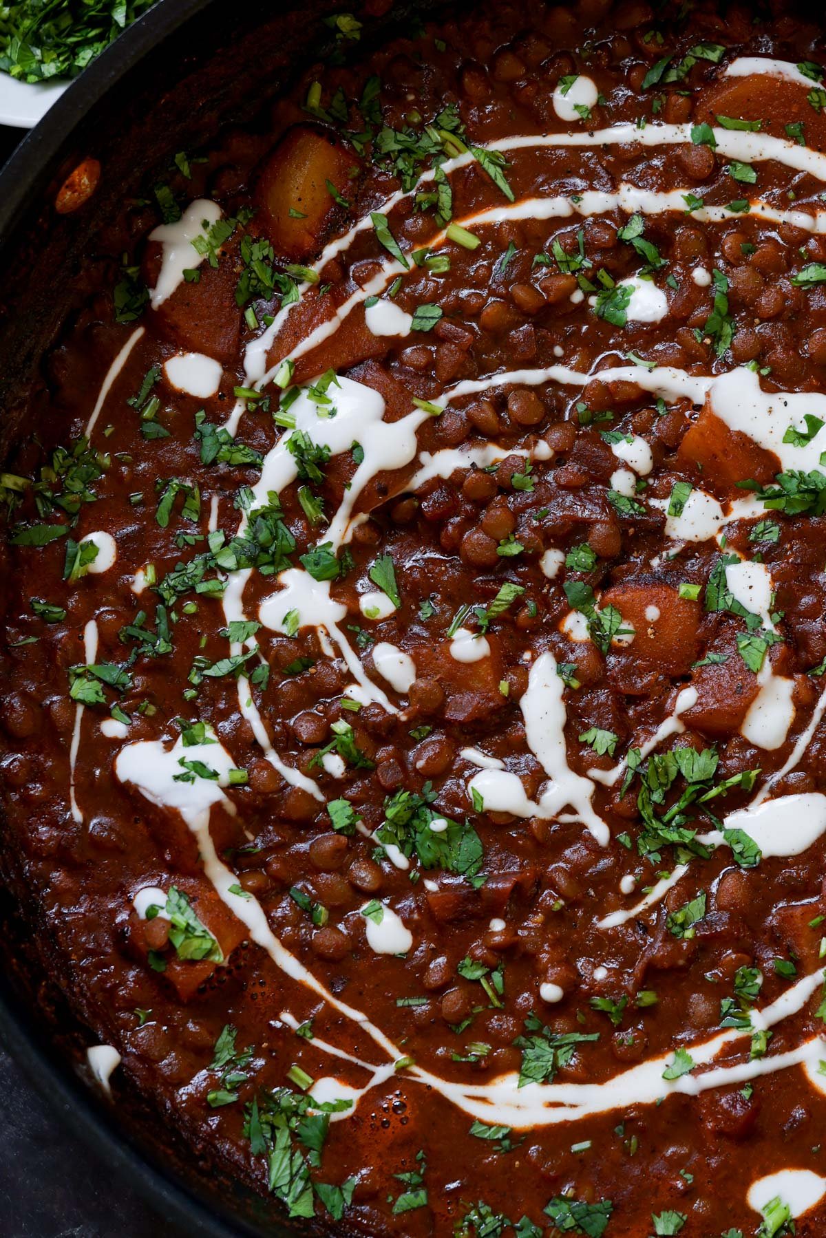 close-up of lentils vindaloo in the pan after adding the toppings