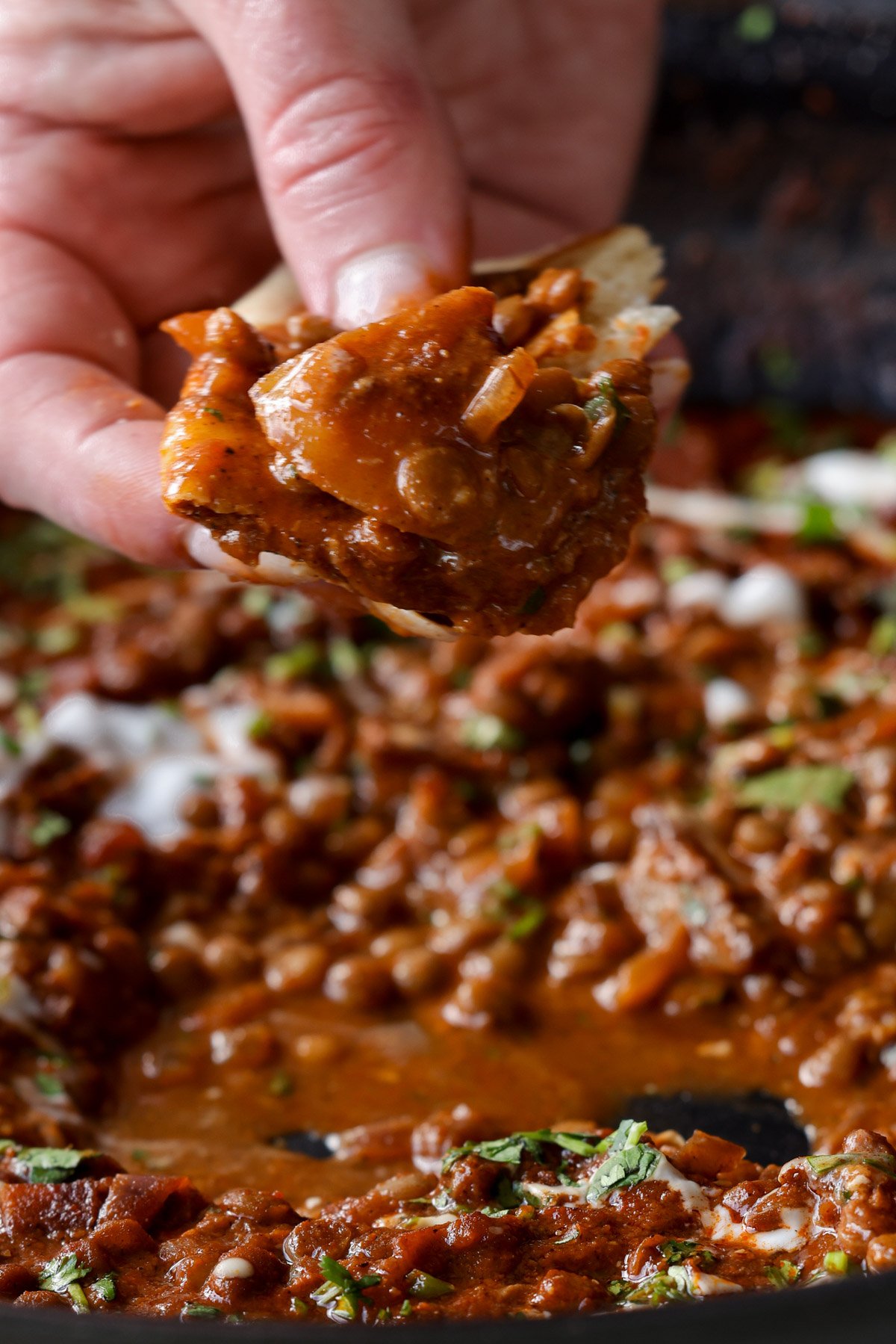 scooping up some lentils vindaloo with naan