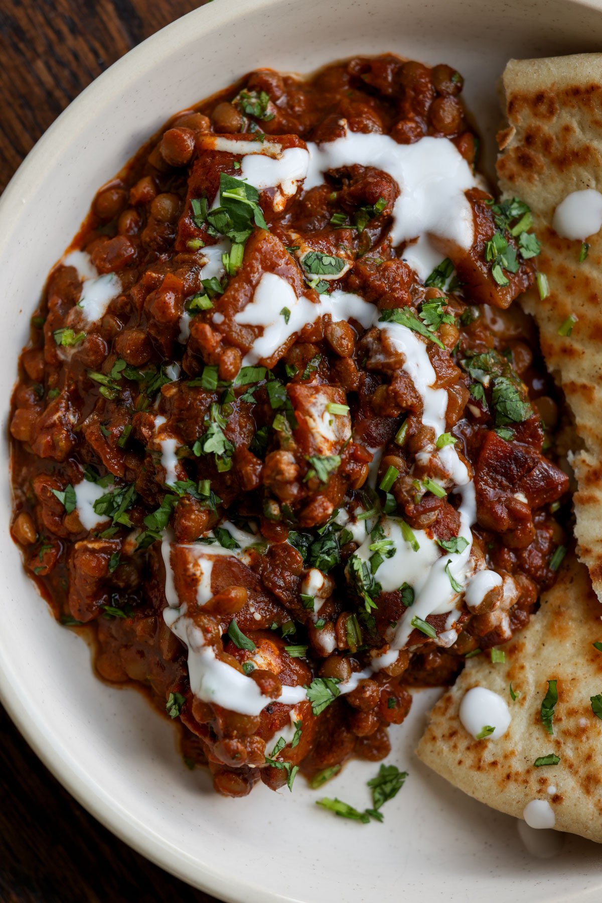 lentils vindaloo on a plate with toppings and naan