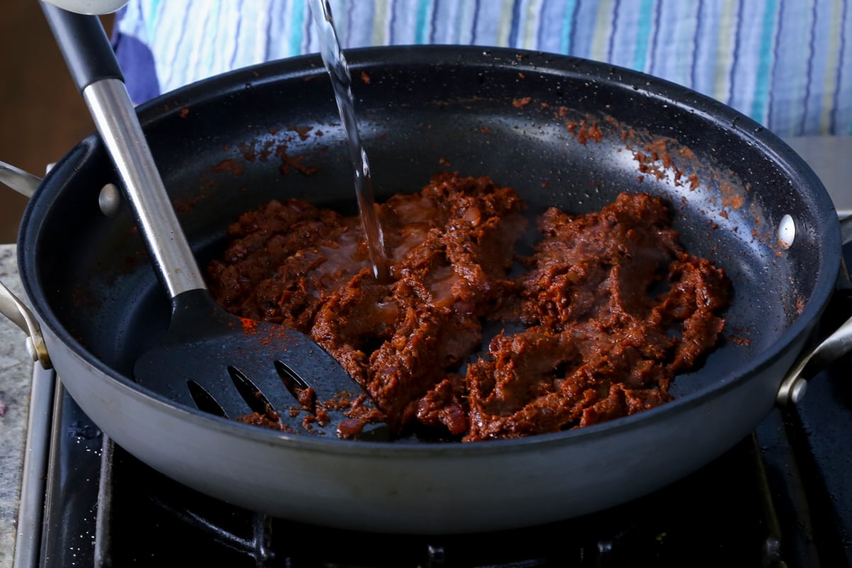 adding water to the vindaloo sauce