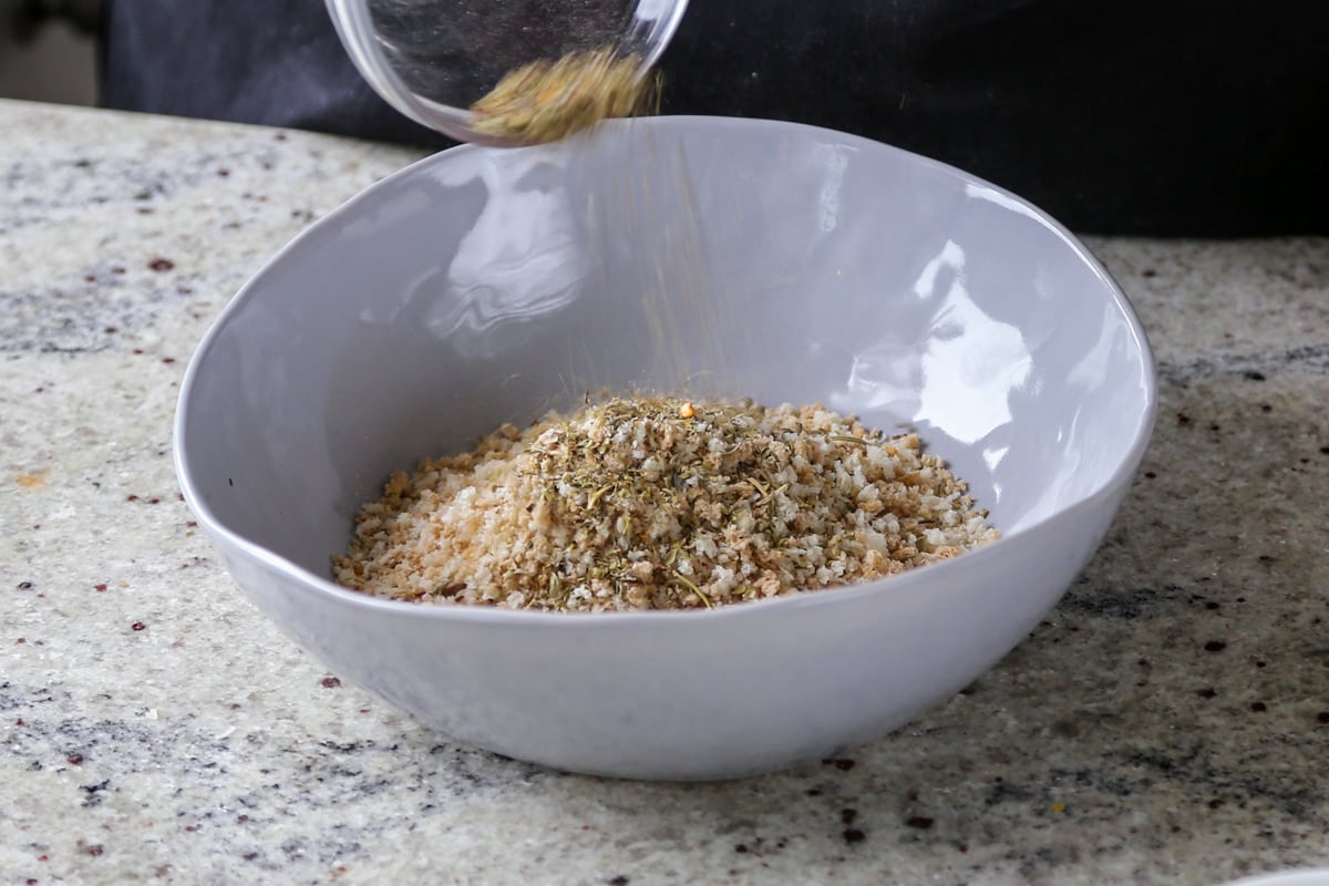 adding breadcrumbs and herbs to a bowl