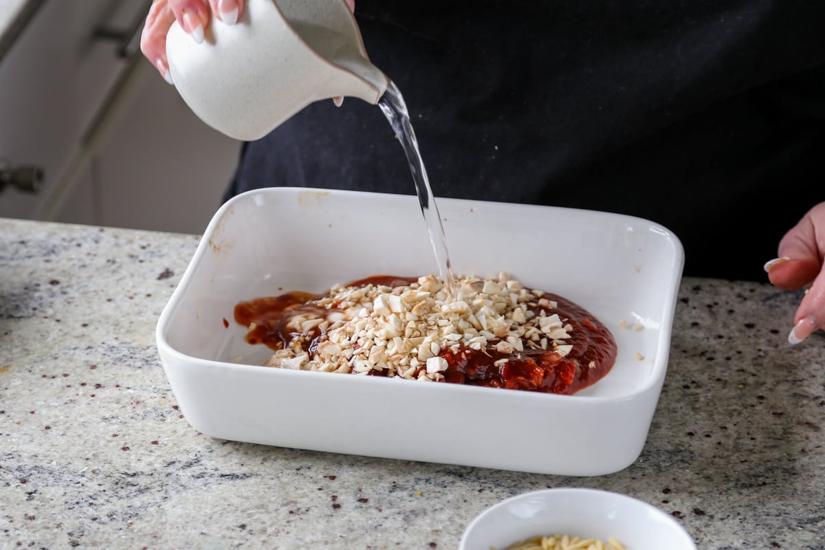 adding mushrooms stems and water to the sauce