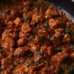 close-up of salli boti in a pan after cooking