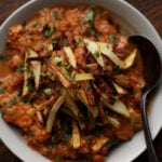 bowl of boti topped with crispy salli potatoes