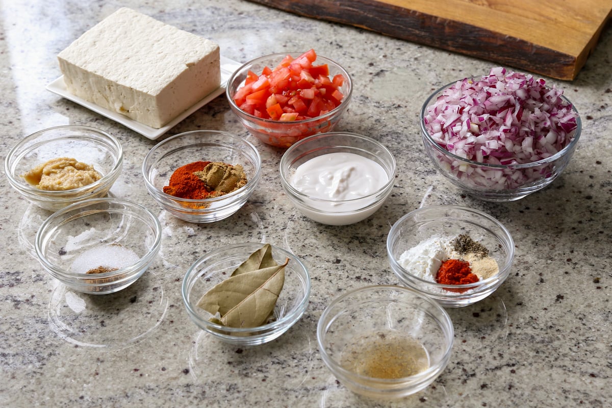 tofu, onions, spices, and other salli boti ingredients on the kitchen counter