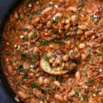 dipping toasted sourdough into vegan sausage pasta sauce in the pan