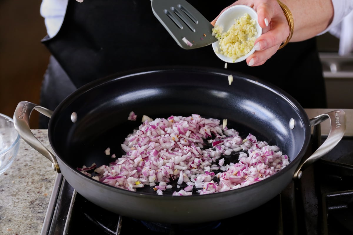 adding onion and garlic to the pan