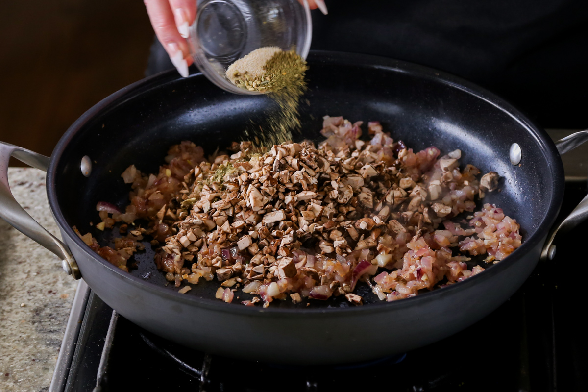 adding some of the spices to the pan