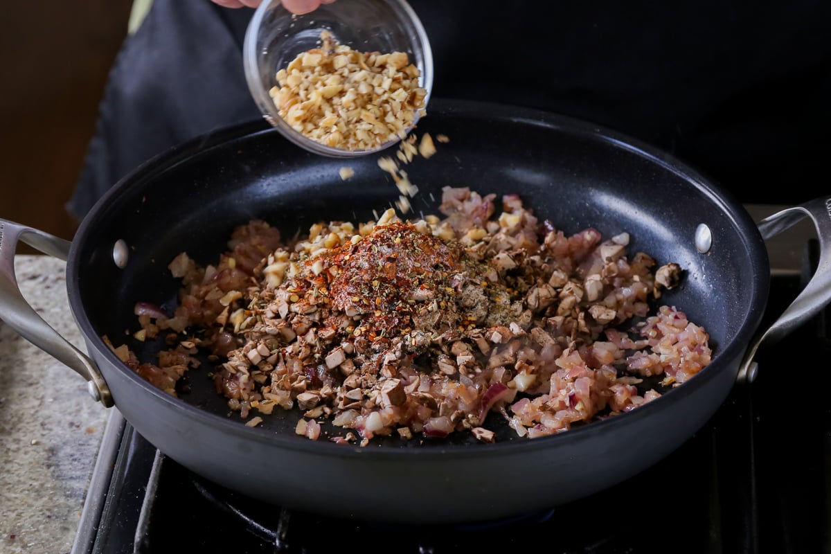 adding chopped walnuts to the pan