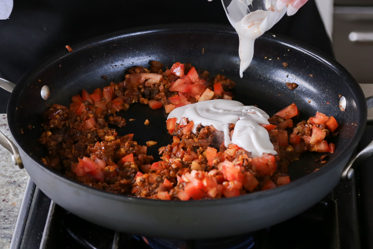 adding tomato and non-dairy cream to the pan