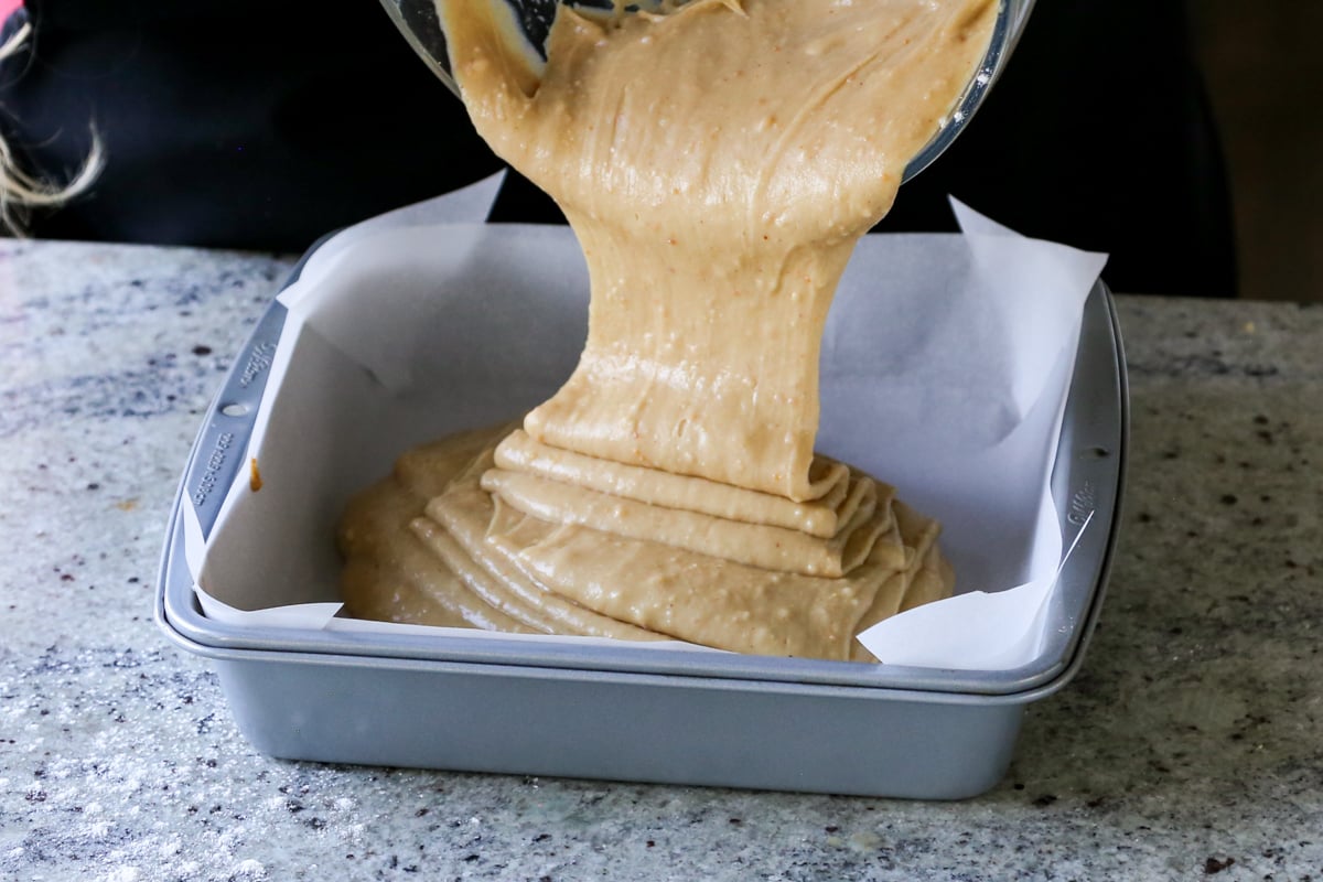 pouring peanut butter cake batter into the pan