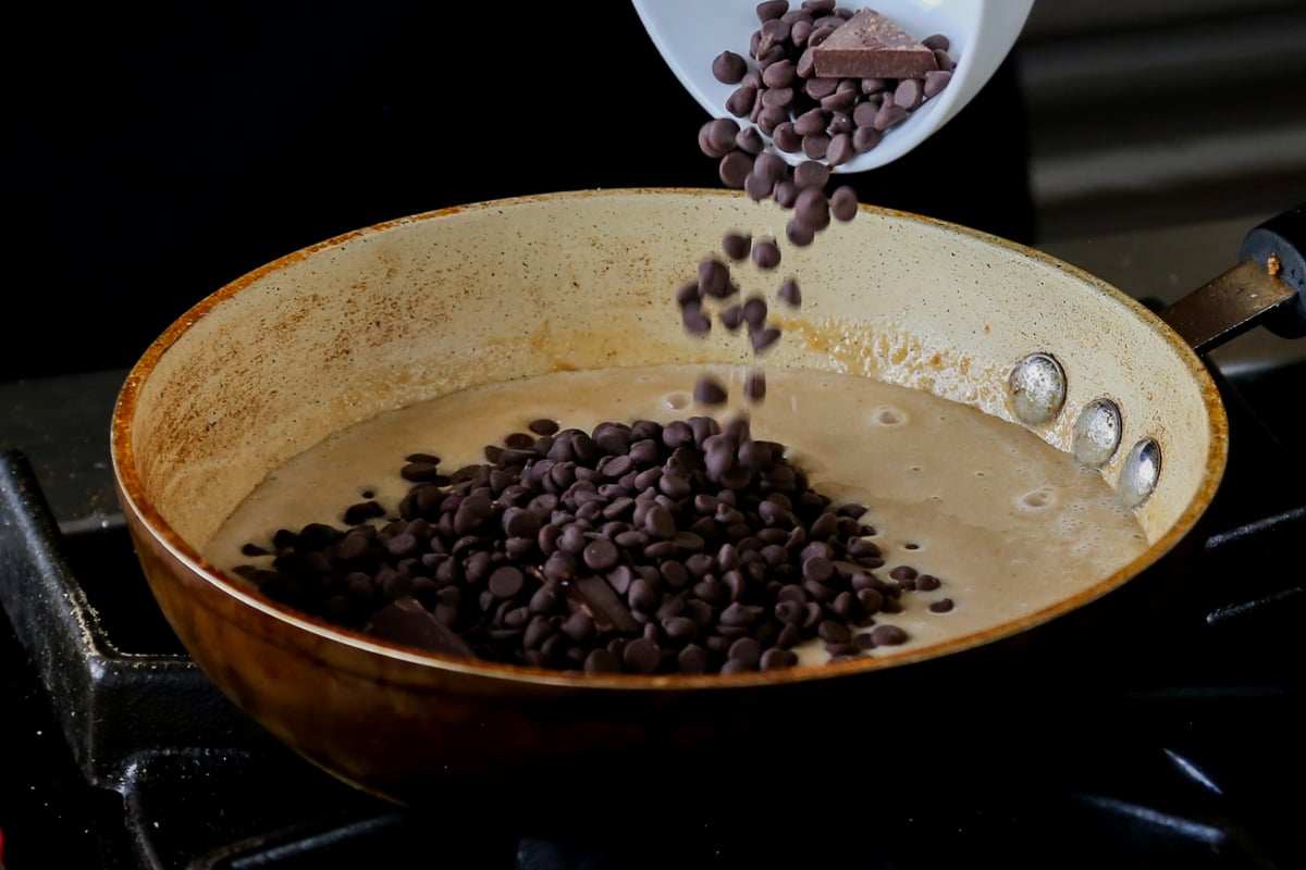 adding chocolate chips to the peanut butter mixture in the pan