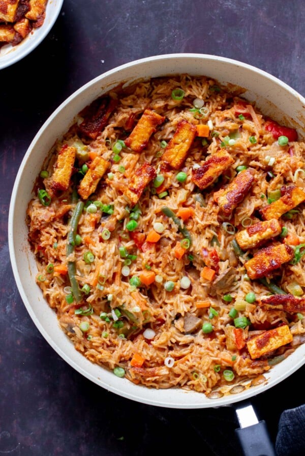 peanut gochujang rice topped with tofu and green onions in a skillet