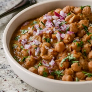 Punjabi chole in a bowl with rice, onion, and cilantro