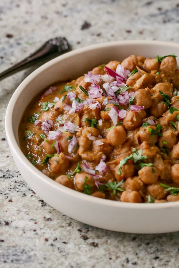 Punjabi chole in a bowl with rice, onion, and cilantro