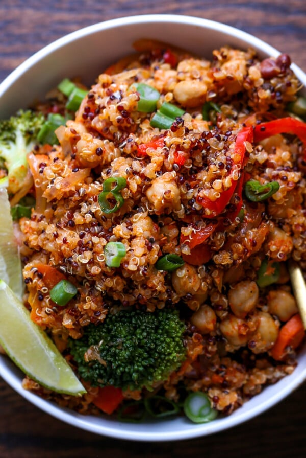 quinoa chickpea casserole in a bowl with lime wedge and green onion