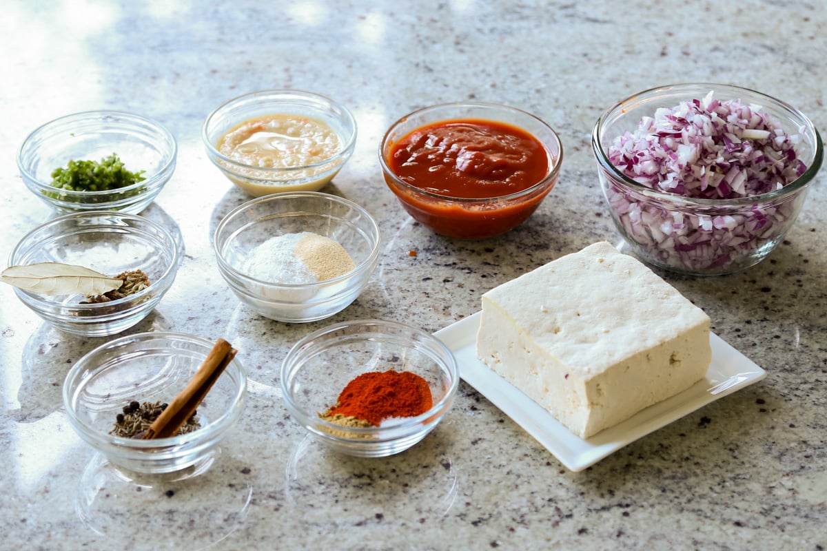 rara chicken curry ingredients in bowls on the kitchen counter