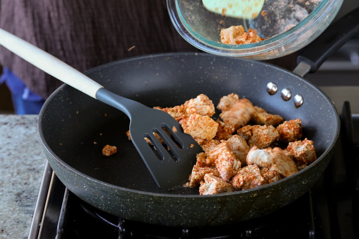 adding tofu to the pan