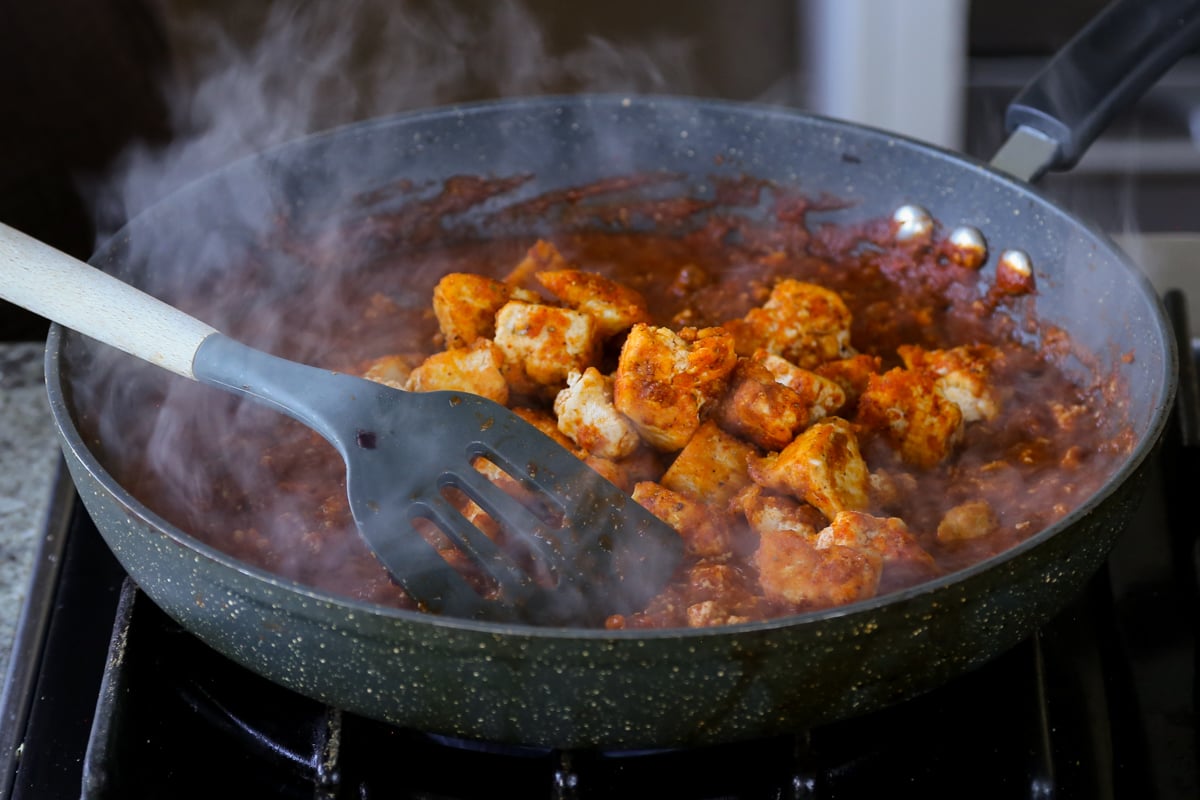 adding the tofu into the rara chicken curry sauce