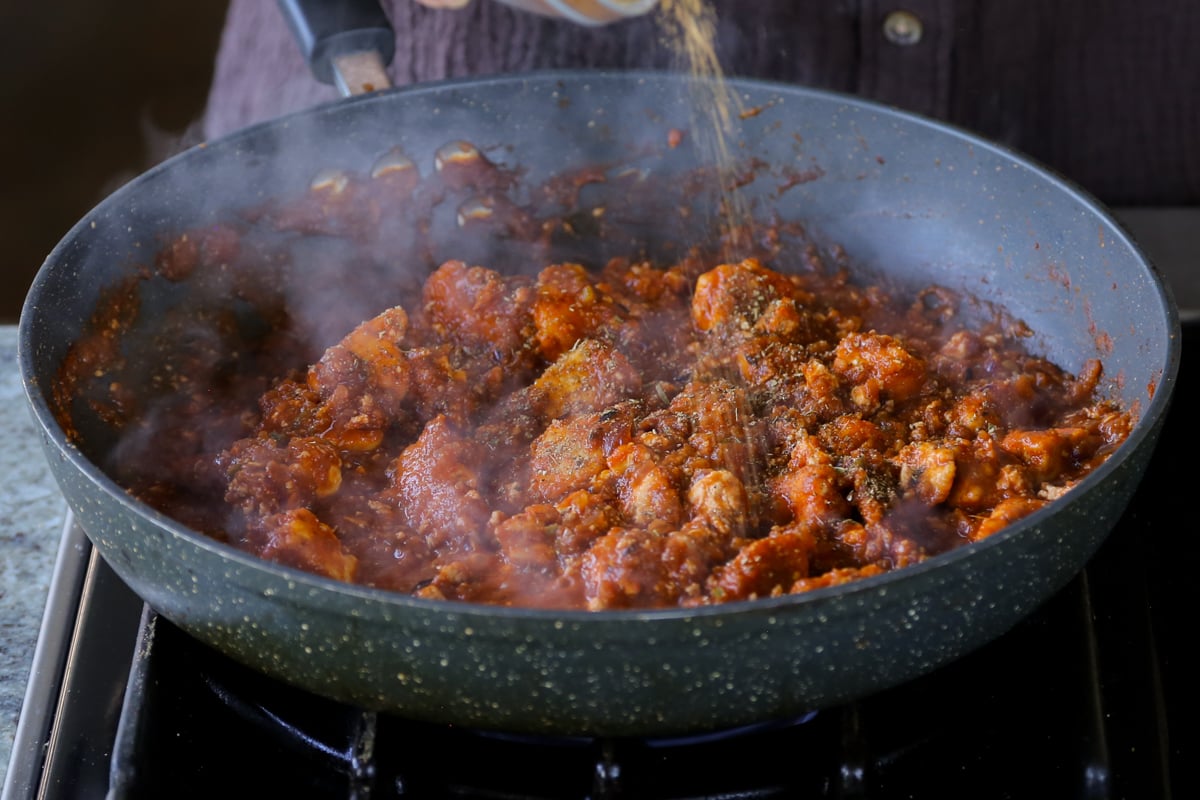 adding more spices to the rara chicken curry sauce with tofu