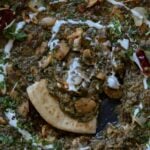 saag butter beans in the pan with a piece of flatbread