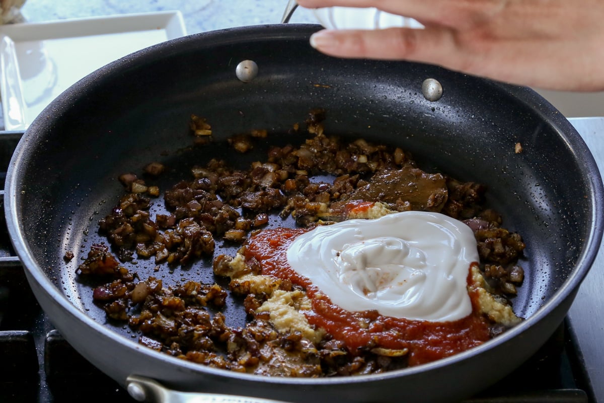 adding ginger garlic paste, tomato paste, and non-dairy yogurt