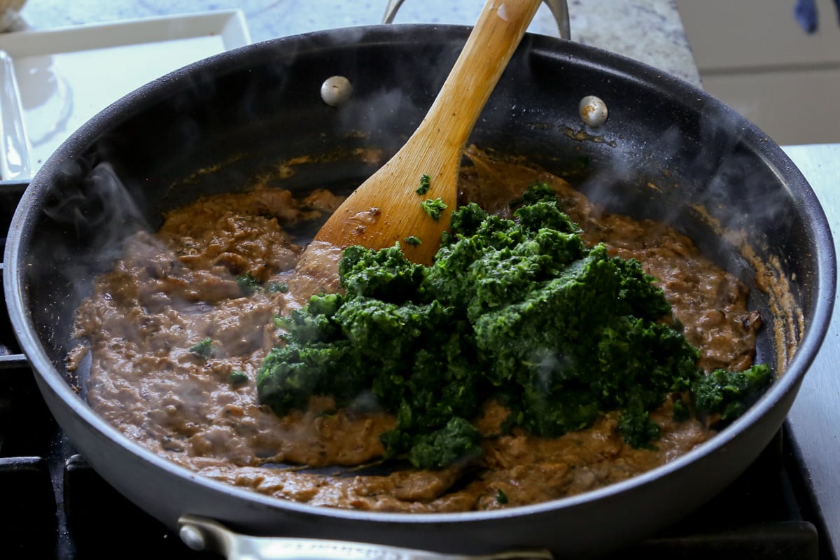 adding the spinach to the pan