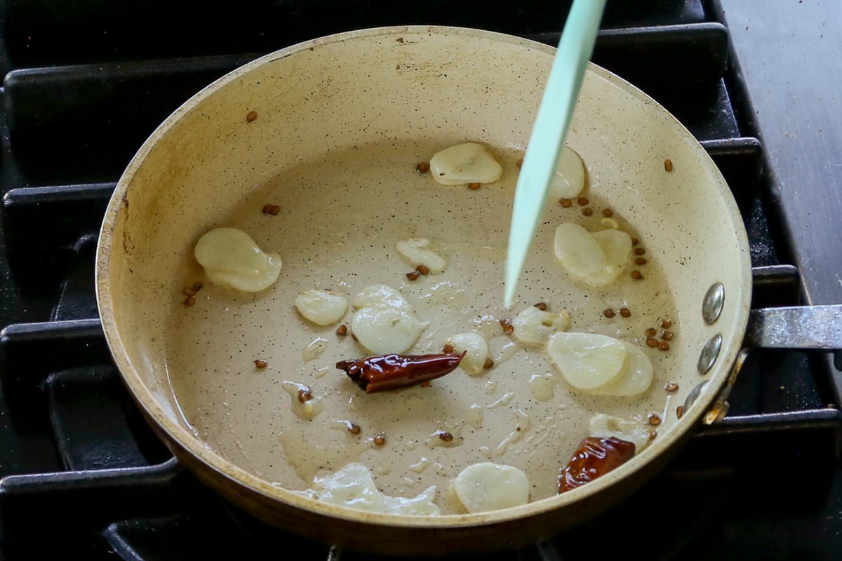 adding sliced garlic in the pan