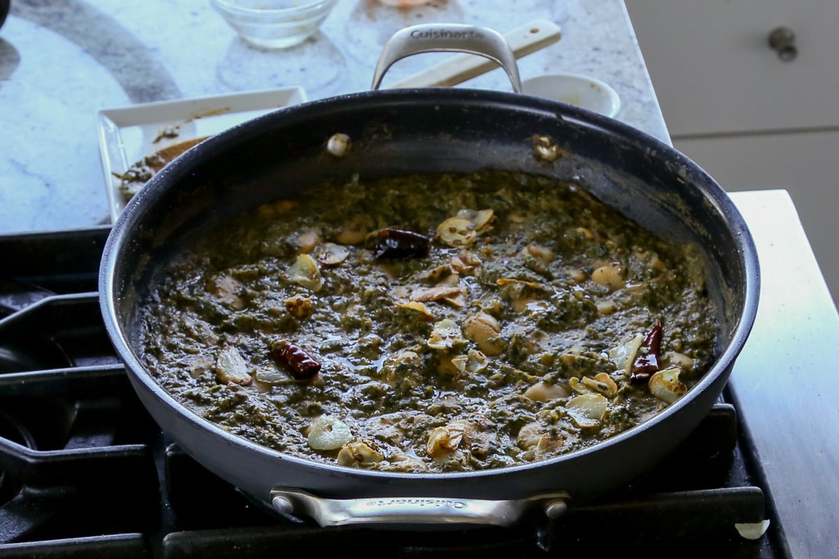 saag butter beans in the pan with garlic chili oil tempering on top