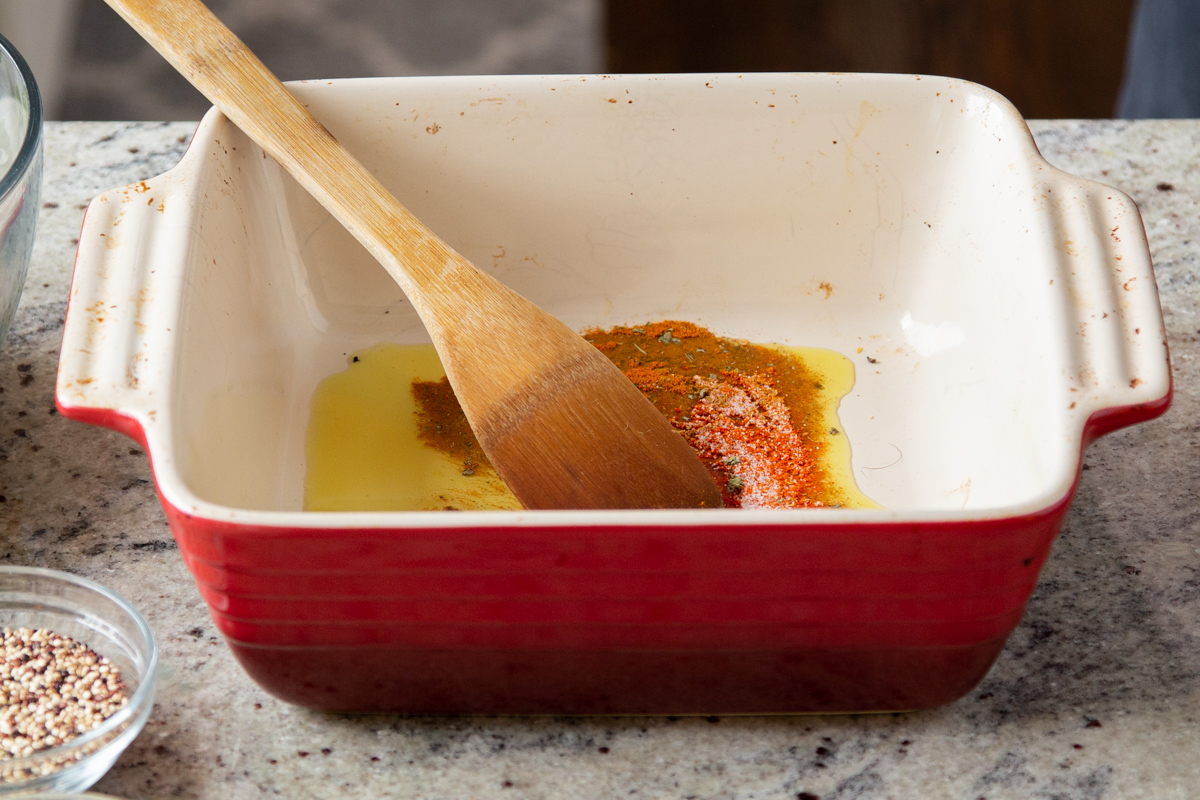 spices and oil in a square red casserole dish