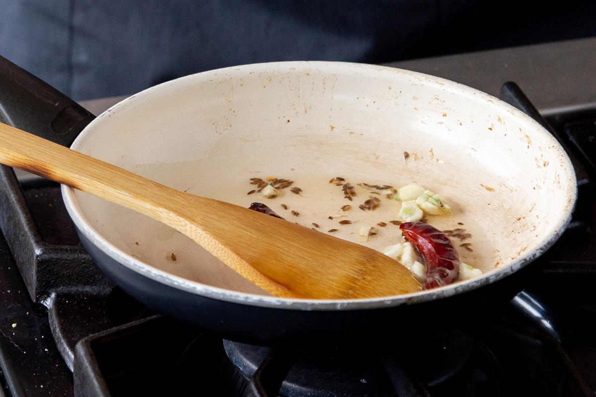 cumin seeds, garlic and chili in a frying pan 