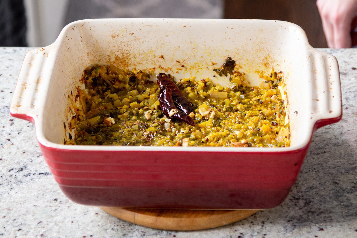 greens, chili and garlic in a red casserole dish