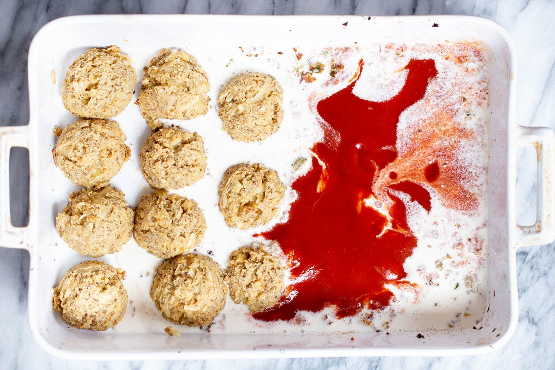 baked vegan tofu koftas in casserole dish with cashew cream and tomato sauce 