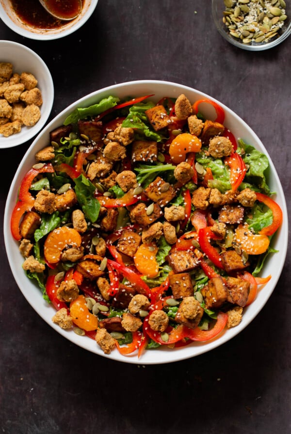 vegan summer salad in a bowl with tofu, croutons, veggies and oranges