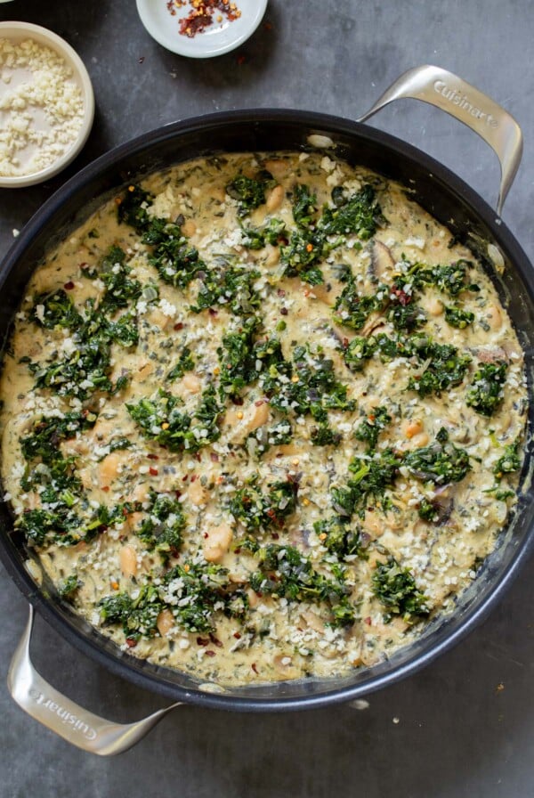 vegan white bean mushroom alfredo in the pan with spinach