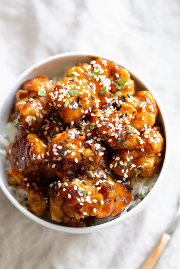 Vegan Sticky Sesame Cauliflower over rice in a white bowl