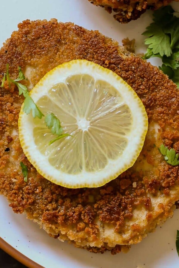 tofu schnitzel on a plate with salad and lemon