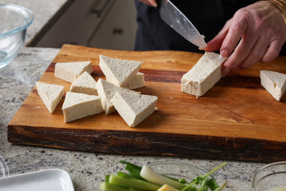 slicing the tofu into fat triangles