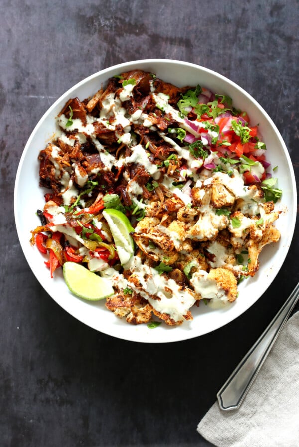 Chili Lime Roasted Veggies & Jackfruit drizzled with jalapeno cream sauce in a White Bowl