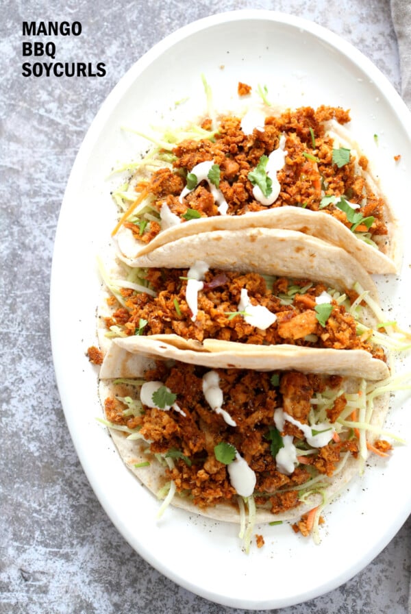 Mango BBQ Soy Curls or Jackfruit Tacos. Shredded Soy Curls or Jackfruit make a an amazing carrier for bbq sauce. Some Mango or other fruit puree takes it to the next level. Serve in sandwiches or tacos with slaw. #Vegan #Glutenfree #Recipe #veganricha | VeganRicha.com