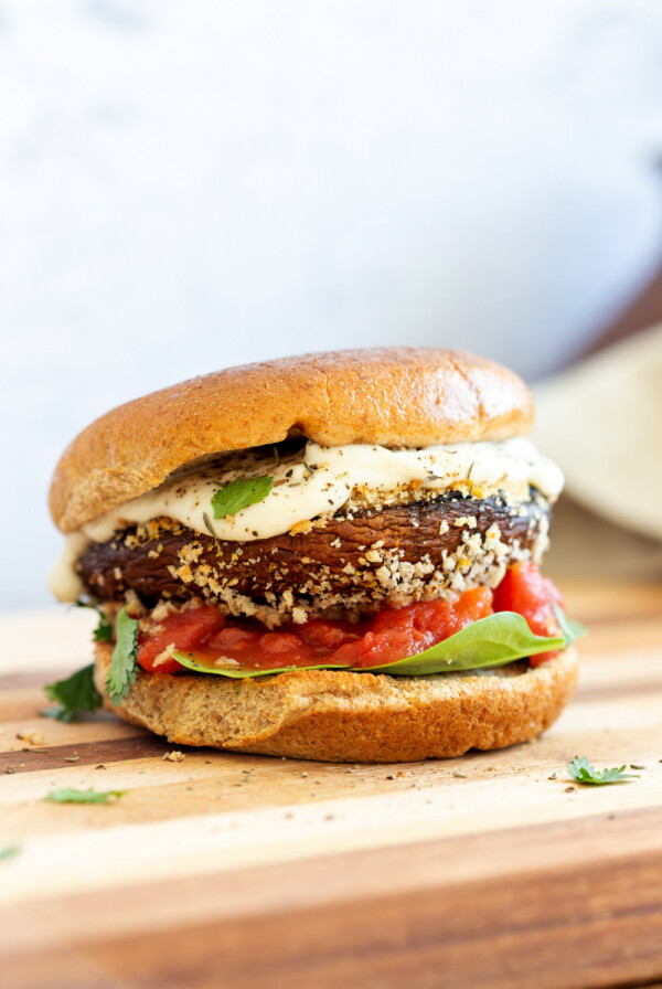 Vegan Portobello Mushroom Burger. Portobello marinated and stuffed with vegan mozzarella, then breaded to make Crispy Portobello Sandwiches! Top with more vegan mozzarella cream, fresh herbs. #Vegan #Recipe #VeganRicha #VeganPortobelloMushroomBurger #breadedportobello. Nutfree Gluten-free options