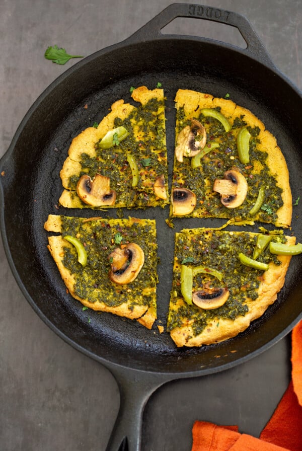 Socca Pizza with chimichurri and mushrooms on cast iron skillet