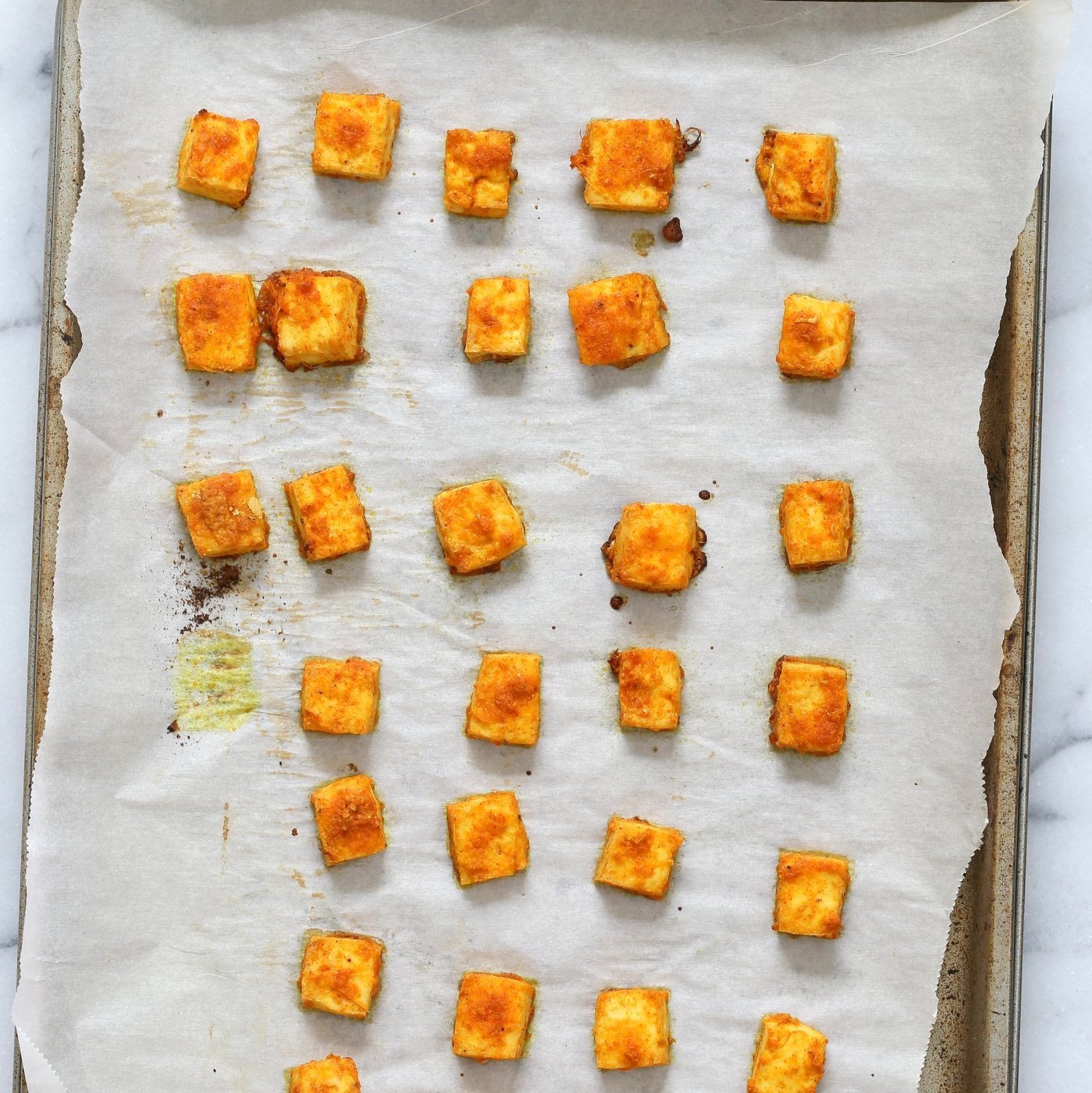 Marinated Tofu Cubes baked on Parchment lined baking sheet for Indian Butter Tofu Masala dish