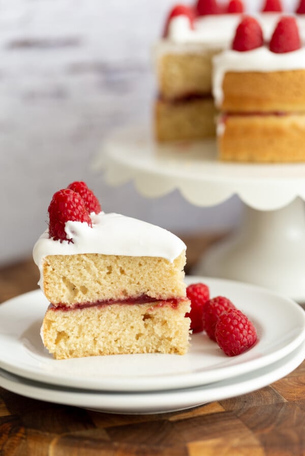 side view of a slice of vegan white cake filled with raspberry jam