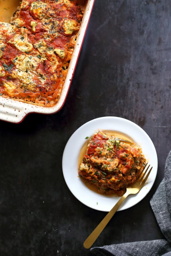 Our Vegan Gluten free Zucchini Lasagna in a cream baking dish and white plate